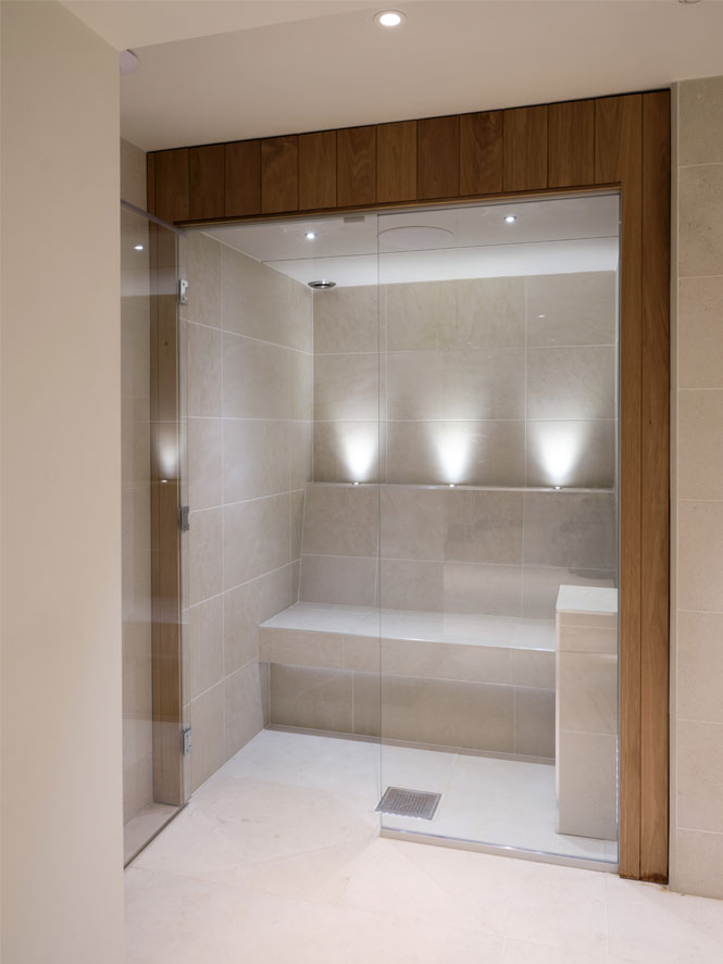 Home spa steam room with uplights and wooden surround