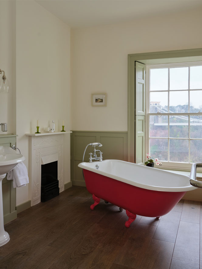 Pink roll top bath in green panelled traditional bathroom