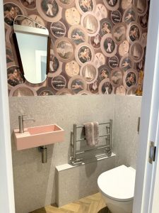 Cloakroom with mulberry home sporting life wallpaper and pink basin with large scale stone tiles below