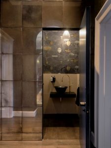 Dark and moody concealed cloakroom behind mirrored door joseph king interiors bristol