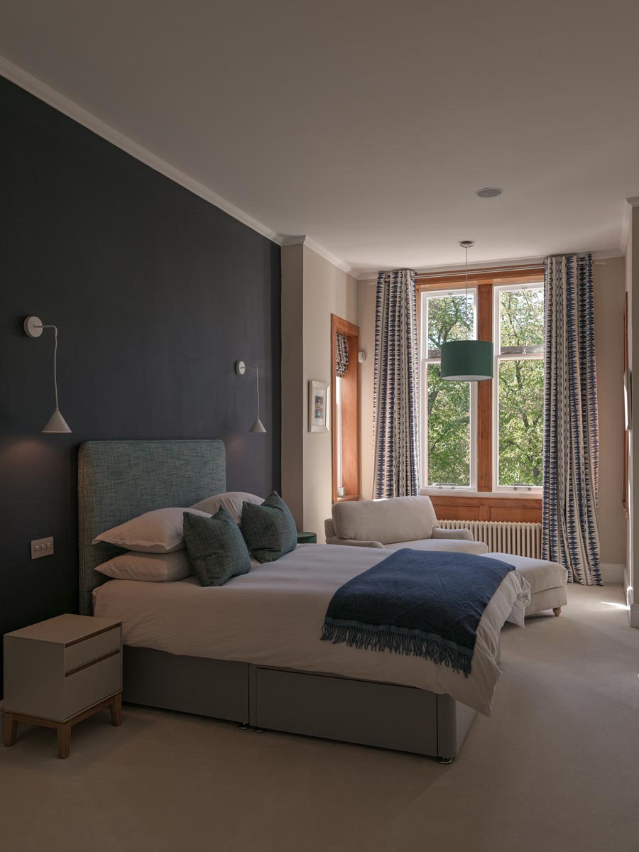 Dark blue accent wall in guest bedroom